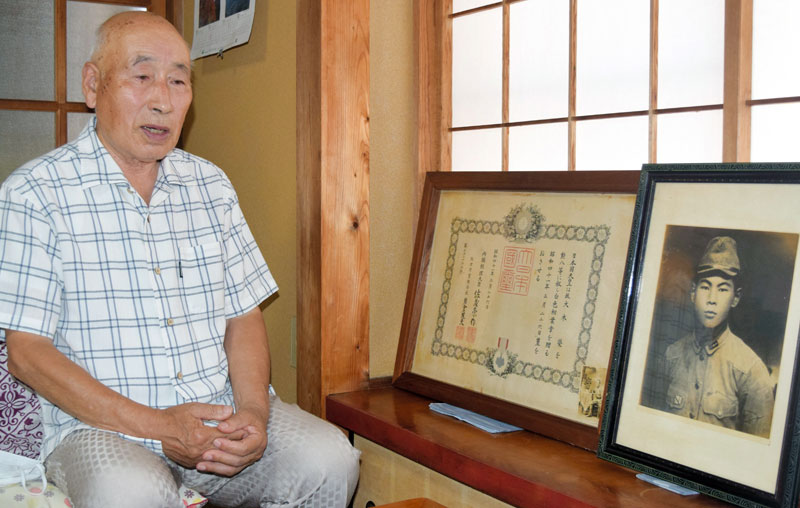 叔父、栄さんの遺影を前に「遺族を再び生み出さないためにも戦争体験を語り継ぐのが重要だ」と訴えた大木さん=12日、栄町