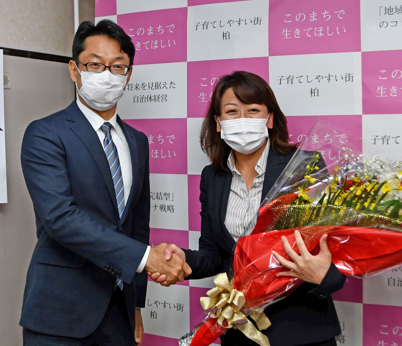 駆け付けた秋山浩保・現市長(左)から祝福を受ける太田氏=1日未明、柏市