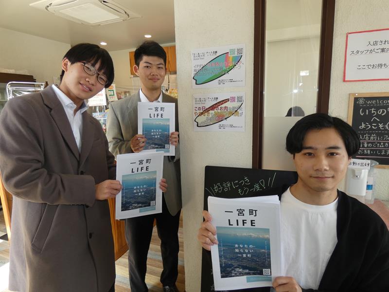 店を訪れてパネルを掲示し、情報誌を置く学生(左から古沢さん、徳田さん、餌取宏晃さん)=一宮町の炭火焼肉いちの宮