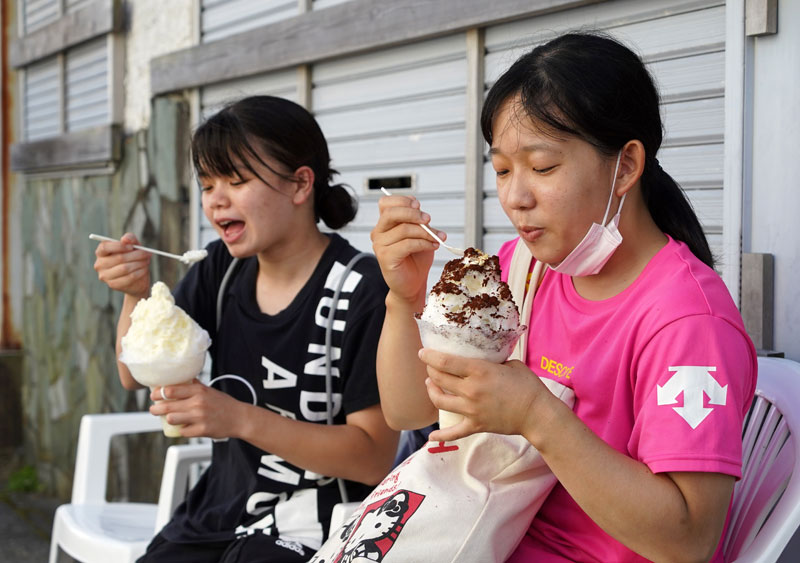 涼を求めかき氷を食べる大学生たち＝２８日午後、勝浦市