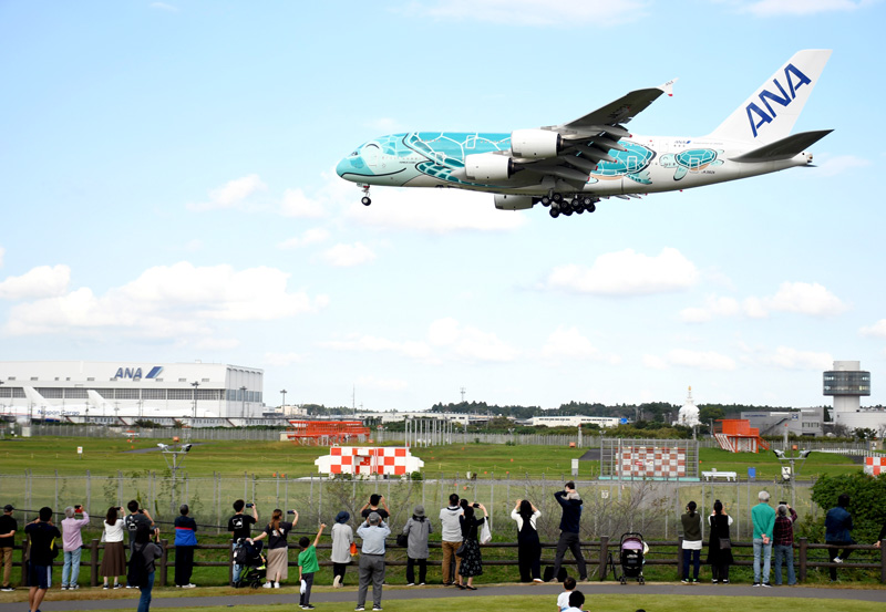 成田空港に着陸する人気の機体を眺めようと、ひこうきの丘に集まる人々=芝山町岩山