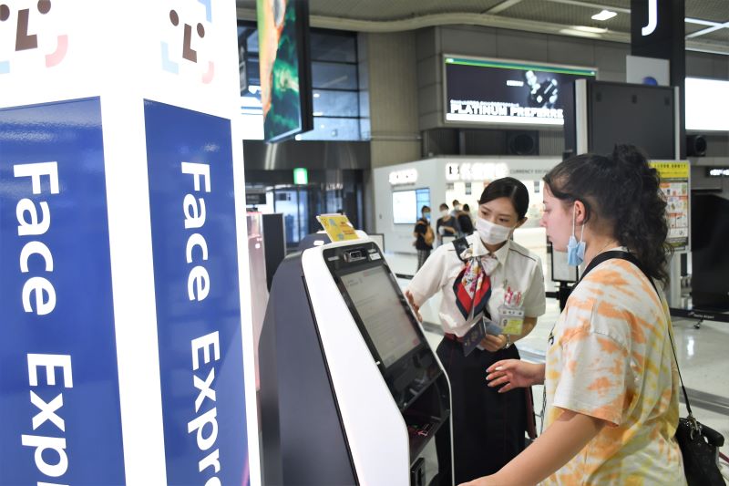 顔認証技術を活用した搭乗手続きシステムを利用する旅客=19日、成田空港第2ターミナル