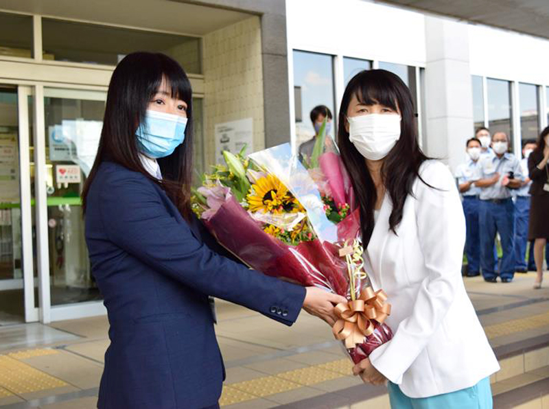 選挙戦から一夜明けて初登庁し、職員から花束を受け取る芝田新市長(右)=19日、鎌ケ谷市