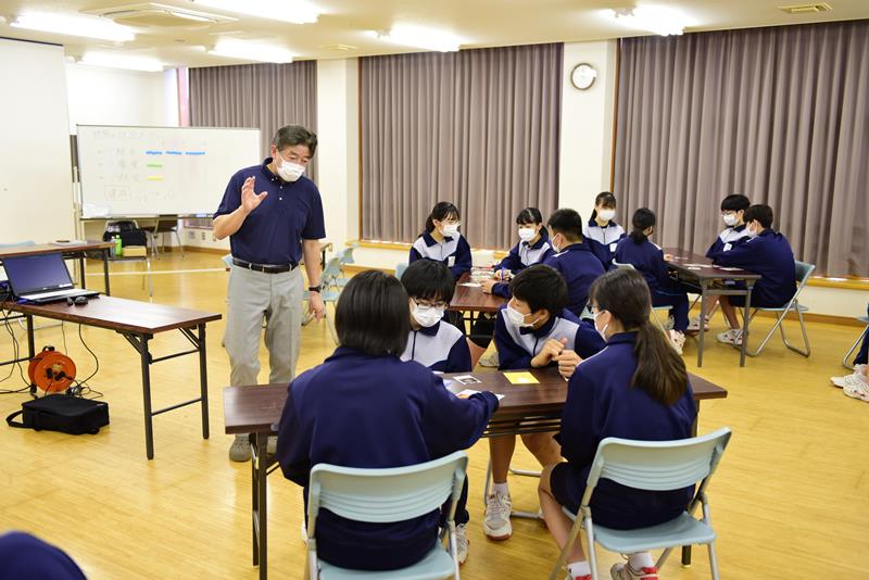ＳＤＧｓを学ぶカードゲームを行う生徒と指導した石毛さん＝東庄町立東庄中