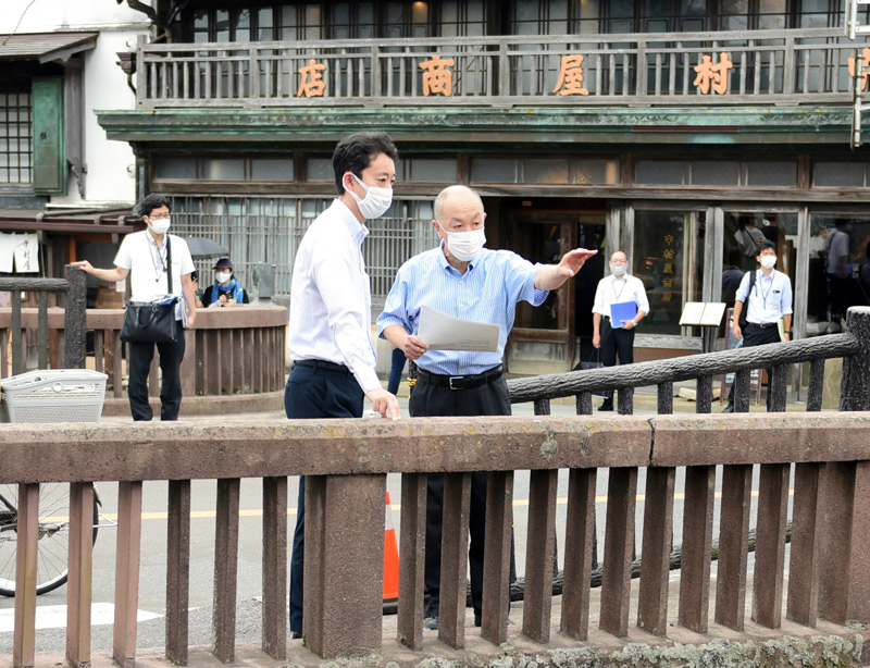 宇井市長（右）から佐原の町並みについて説明を受ける熊谷知事＝２日、香取市