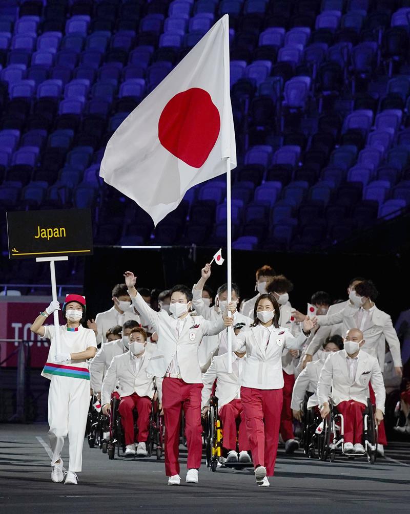 東京パラリンピックの開会式で、旗手の岩渕幸洋（手前左）と谷真海を先頭に入場行進する日本選手団＝２４日夜、国立競技場（共同）