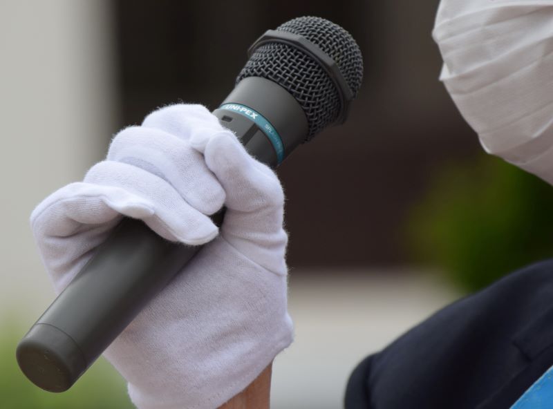 マイクを握りしめ、支持を訴える候補者=19日