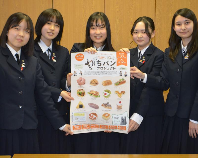 地元店と協力して開発したご当地パンをポスターでPRする八千代高の生徒=八千代市役所