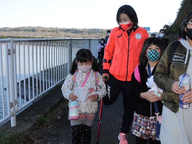 手術直後に市民ウオーキング大会に参加し交流する秦選手(中央)=11月28日、市原市の高滝湖畔