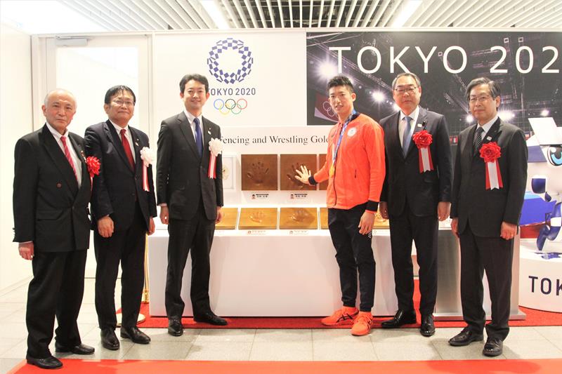 幕張メッセの東京五輪・パラリンピック展示コーナーで自身の手形に手を合わせる見延選手(右から3人目)ら=25日、千葉市美浜区