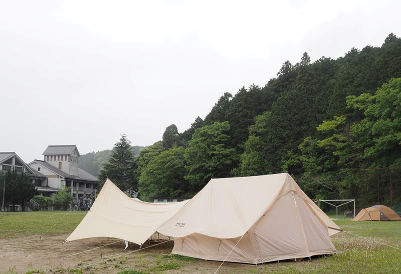 テントが張られた旧亀山中のグラウンド(左後ろは校舎)