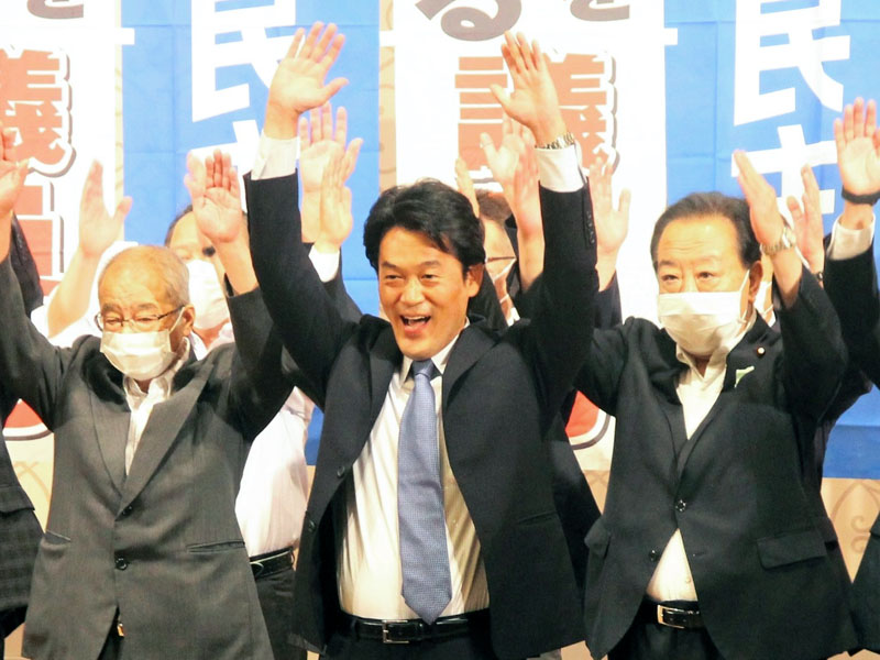 3選を決め、万歳三唱する小西氏(中央)=10日、千葉市中央区