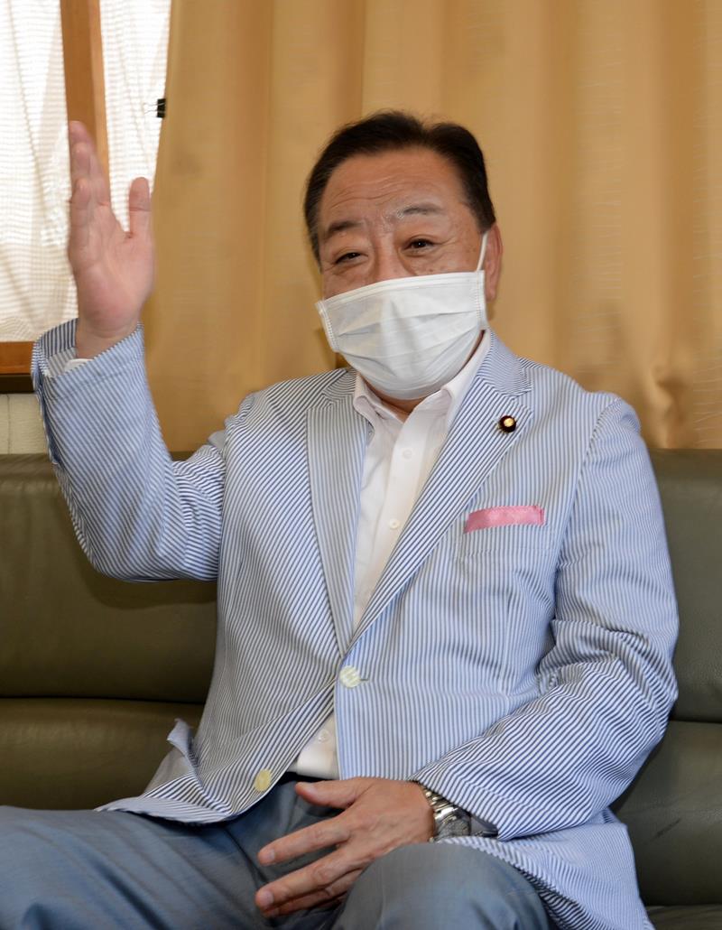 提案された区割り案について、真っ二つとなった船橋市の状況を手刀を振り下ろして表現する野田元首相＝同市の野田議員事務所