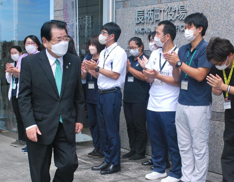 職員に拍手で見送られ町役場を後にする清田氏＝１２日、長柄町役場