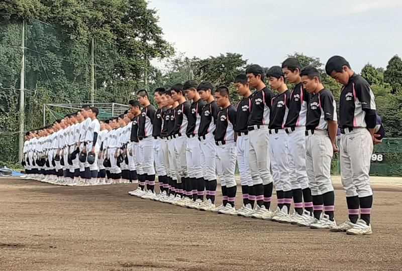 追悼式で黙祷する佐倉高(手前)と千葉黎明高の選手たち=22日、佐倉市の佐倉高グラウンド