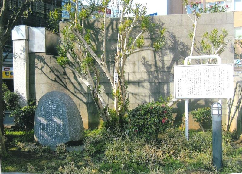 船橋市文化センター前に建つ夾竹桃と、ライオンズクラブが建立した石碑と、船橋市教育委員会の案内版。背後の夾竹桃は太宰治が船橋の居宅玄関に植えた木をこの地に移植した。石碑には「十五年間」からとられた一文が刻まれている