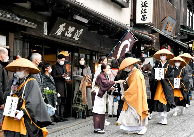 成田山参道でたすけあい托鉢を行う新勝寺の僧侶ら＝成田市
