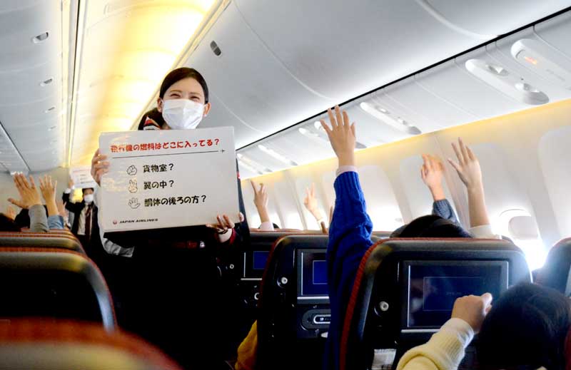三択式クイズで児童に飛行機に関する知識を教える日本航空の客室乗務員