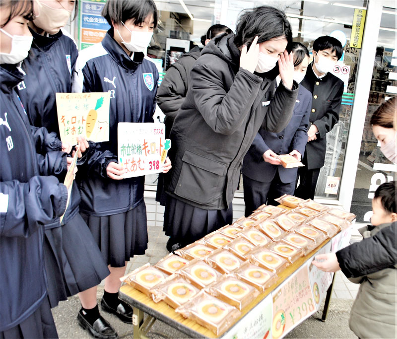 自分たちで開発したご当地スイーツ「市立船橋キャロットばあむ」を店頭販売する生徒たち=15日、船橋市