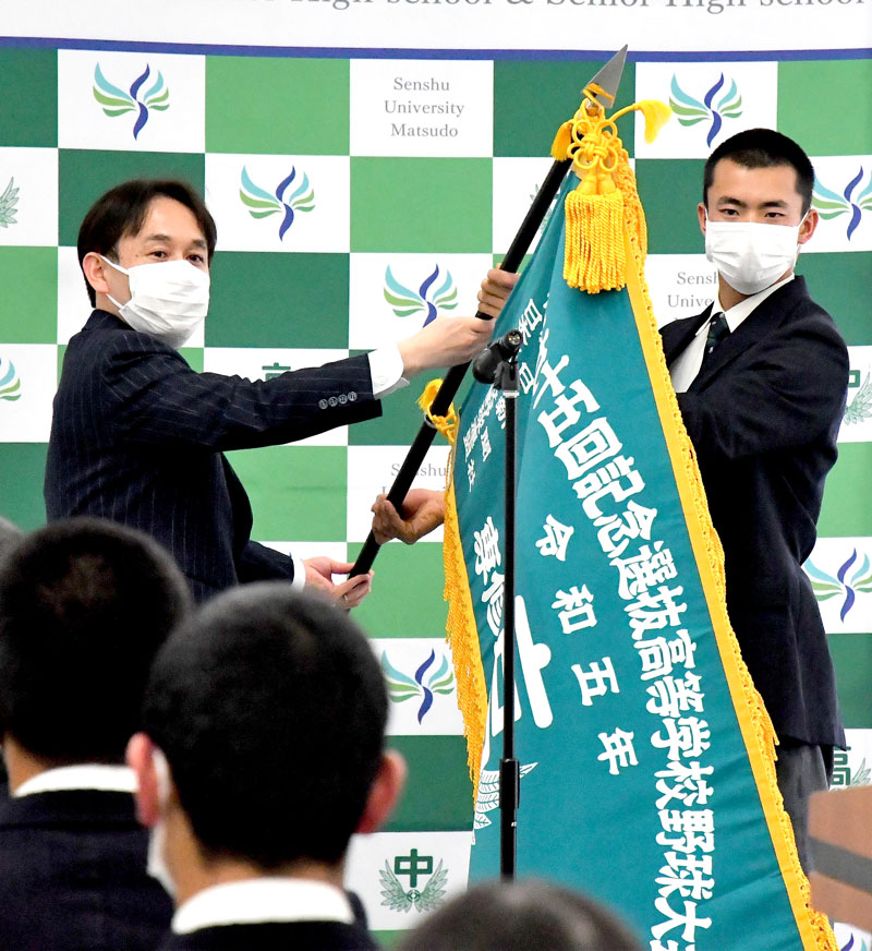 選抜旗を受け取る専大松戸の大森主将（右）。左は五味校長＝松戸市