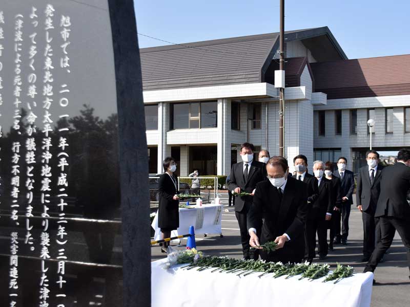 黙とう後に慰霊碑に献花する米本弥一郎市長(手前)=11日、旭市横根のいいおかユートピアセンター