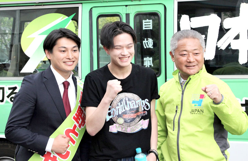 街頭演説後に若い聴衆と記念撮影する岸野氏（左）と馬場代表（右）＝１８日、浦安市
