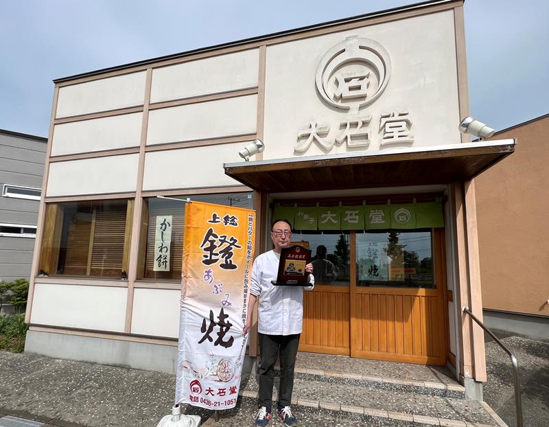 「大石堂」の新店舗で、受賞盾を手にする布施社長=市原市