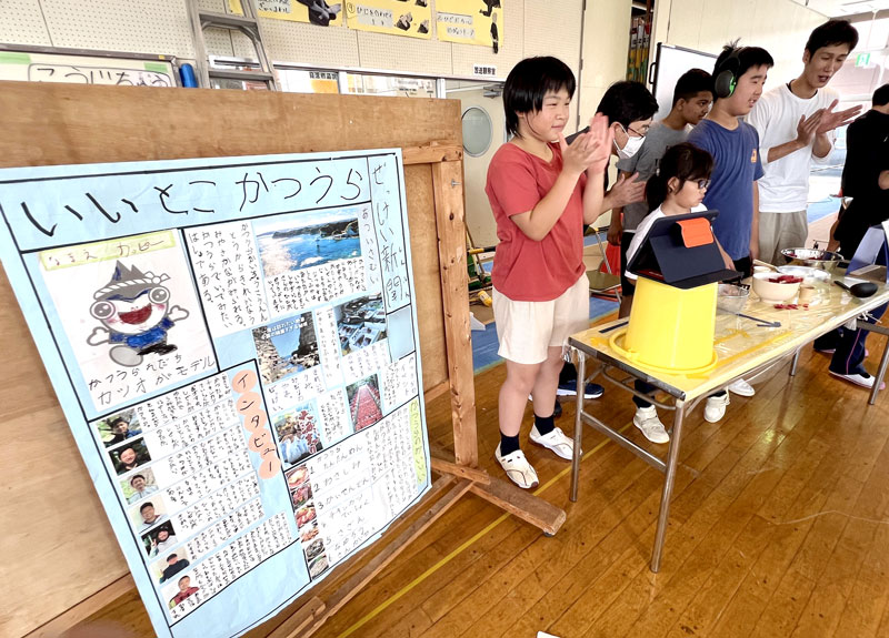 手作りの新聞を発表する中学部1年の生徒。右は菊池教諭=船橋市立船橋特別支援学校