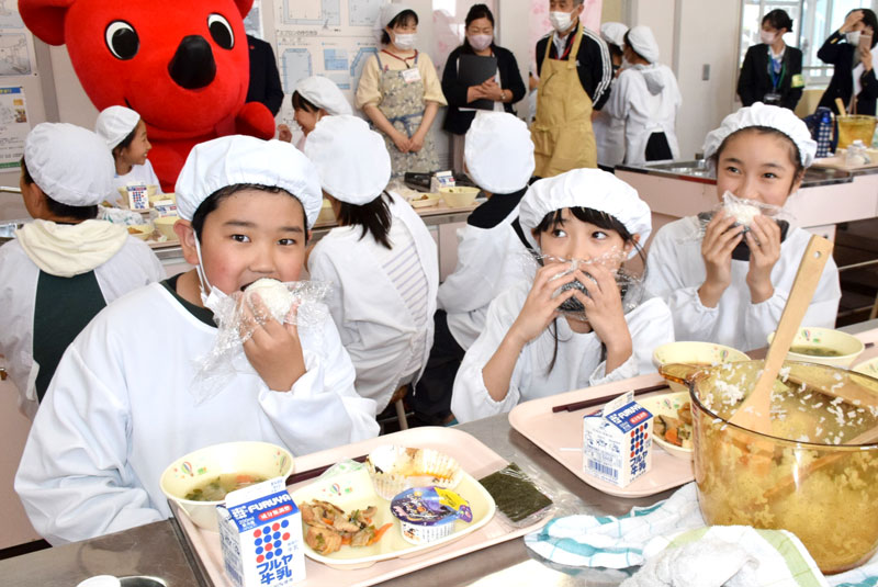 自分たちで炊いておむすびにした「粒すけ」を頬張る児童たち=31日、旭市