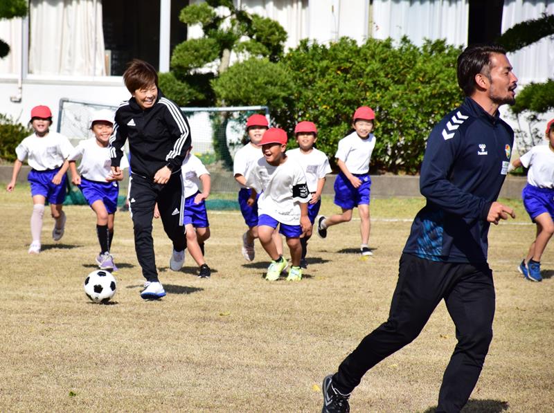 宮間さん(左)、佐藤さん(右)とボールを追いかける児童=白子町立関小