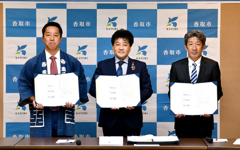 旧府馬小の利活用へ締結式に臨んだ伊藤市長(中央)ら=香取市役所
