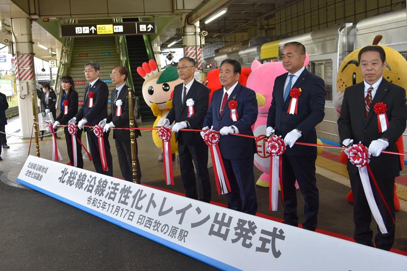 各首長らが出席した沿線地域をPRする全面広告付き電車「北総線沿線活性化トレイン」の出発式=17日、印西市の印西牧の原駅