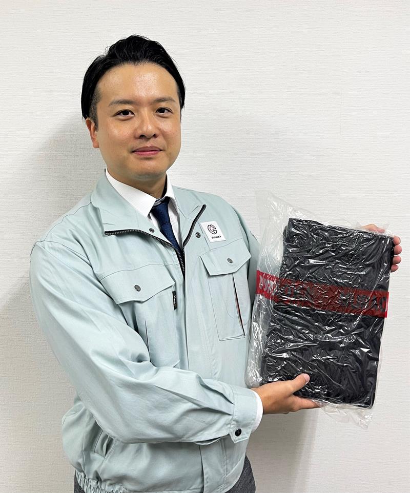 再生ゴムを見せる村岡良亮社長