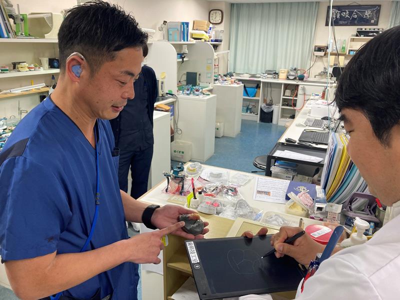 筆談ボードも活用して仕事のやり取りをする村上さん＝旭市