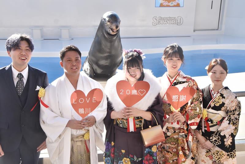 笑うアシカで人気の「カンジ」と一緒に笑顔を浮かべる斎藤さん(左から2人目)ら実行委員=7日、鴨川市