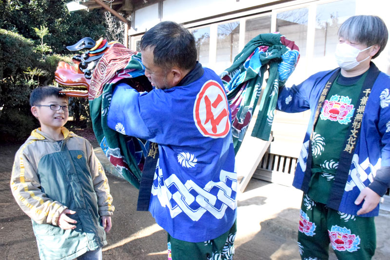 無病息災などを祈願する獅子に頭をかんでもらう子ども＝１４日、匝瑳市