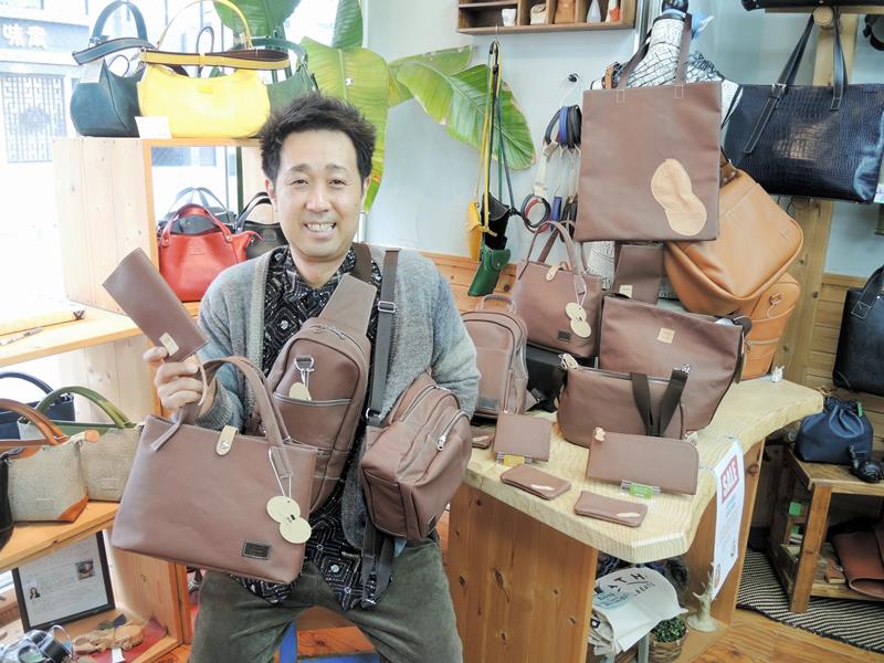 「ピーナッツレザー」を使った商品に囲まれる飯島社長＝柏市