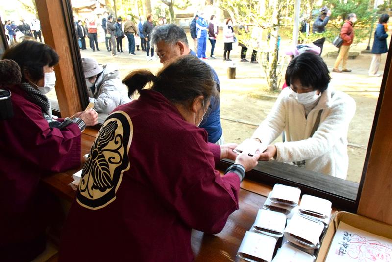 「とがらしごぼう」を受け取る参拝者ら=18日、旭市