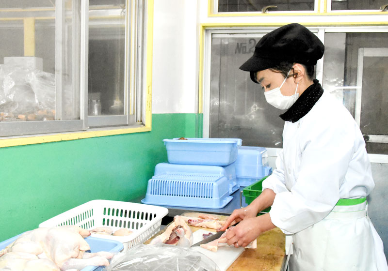 鶏肉をさばく孝子さん=鴨川市