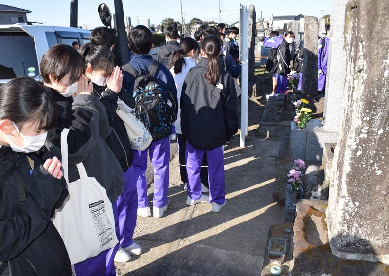 元禄地震の供養碑に手を合わせ、教訓を胸に刻む長生中防災部の部員ら=3日、長生村の本興寺