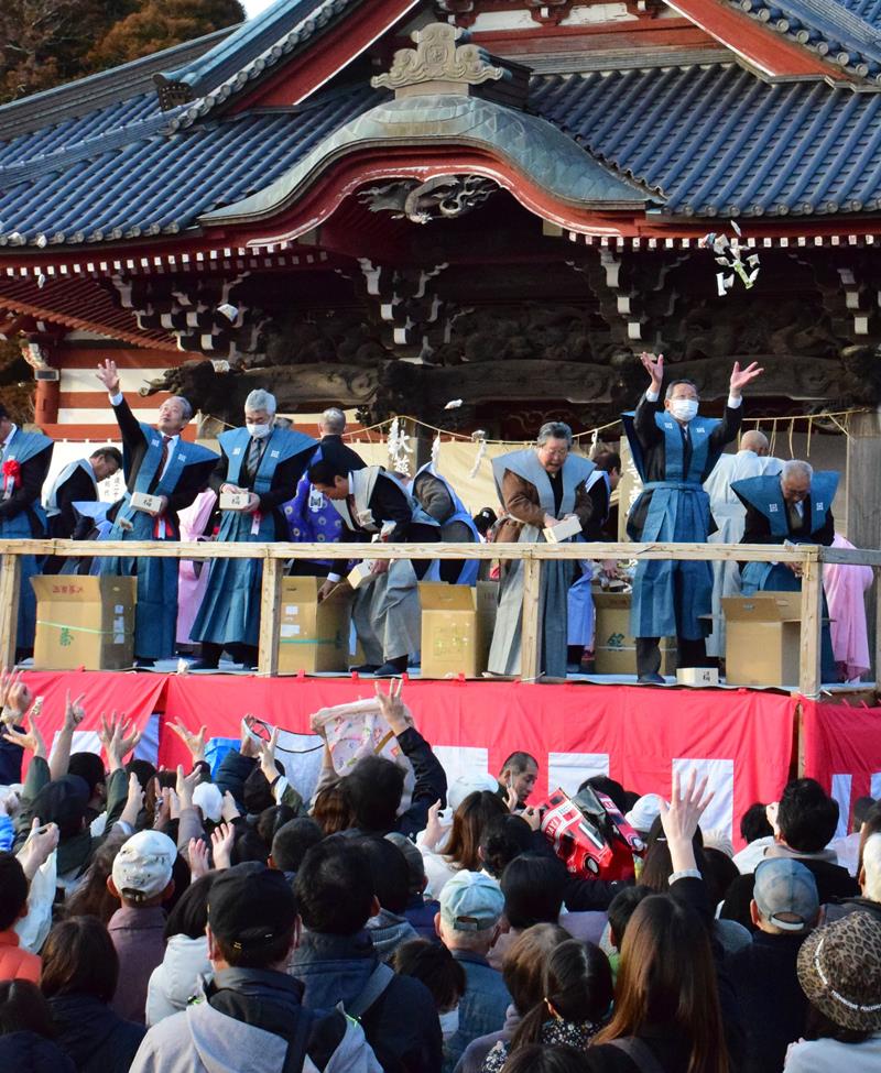 特設の舞台からまかれる豆を取ろうと手を伸ばす来場者=3日、茂原市の藻原寺