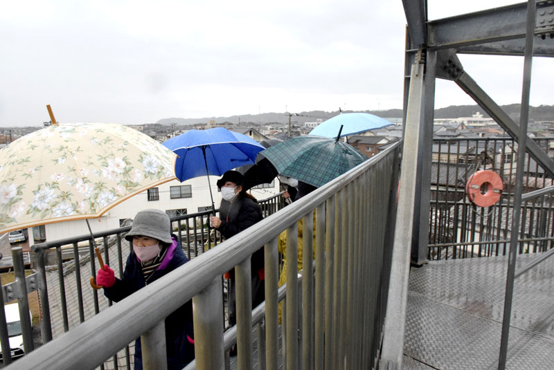 雨の中、訓練で津波避難タワーを上がる市民＝２５日、旭市