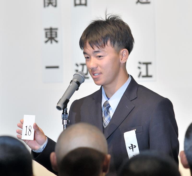 抽選会で引いた「18」の番号札を読み上げる中央学院の中村研心主将=大阪市内