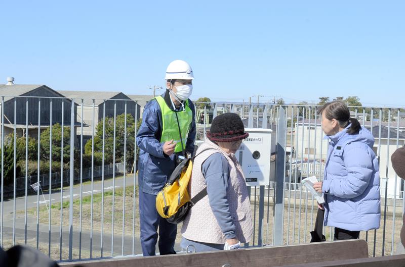 訓練で津波避難タワーを登った住民に防災設備の説明を行う市職員＝１０日、大網白里市