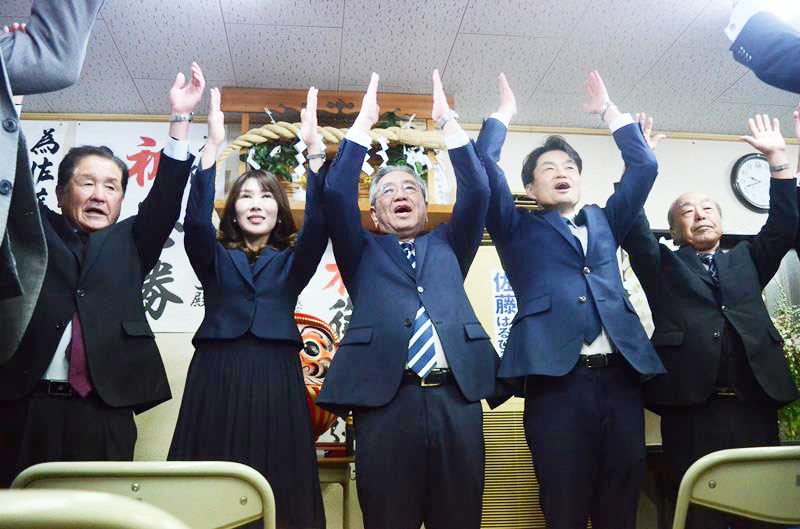 横芝光町長選で5回目の当選を決め、支持者らと万歳する佐藤氏(中央)=17日夜、同町