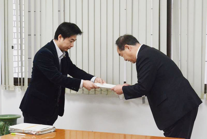 松下市長(右)に報告書を提出する拝師弁護士=18日、山武市役所