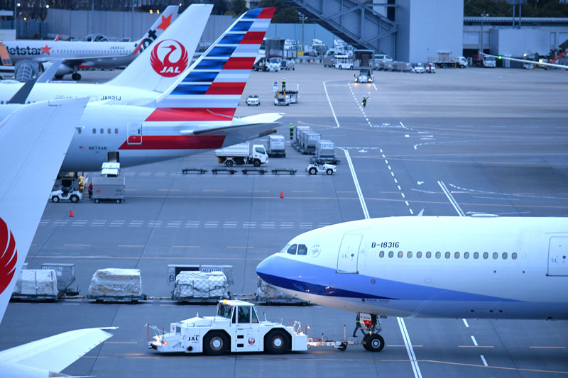 航空機や貨物コンテナのけん引車などグランドハンドリング業務の機材がせわしなく稼働する成田空港＝２８日、成田市