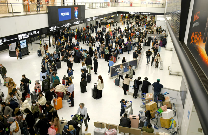 外国人旅客で混み合う成田空港の国際線到着ロビー＝３月２２日、成田市