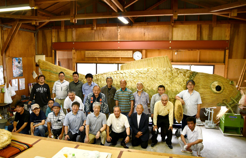 金色煮輝く鯉の前で完成を祝う八日市場区の住民ら＝６月３０日