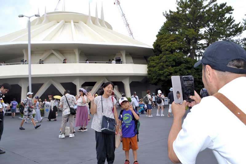 スペース・マウンテンの前で写真撮影する親子=31日、浦安市の東京ディズニーランド